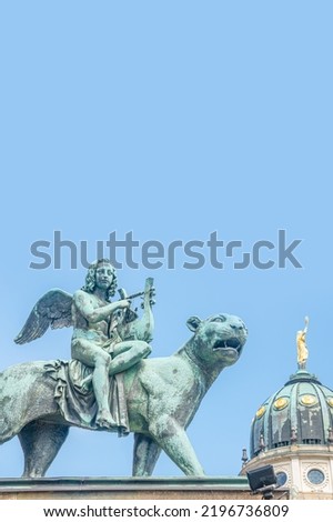 Statue of a panther with genius of music, an angel with wings and a harp, stringed musical instrument at Concert Hall in Berlin, Germany, with copy space as blue sky background