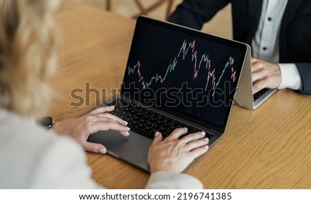 Trading stocks online on the trading exchange colleagues team a woman and a man in business suits in the office