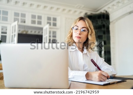 Female manager working in office online report using laptop