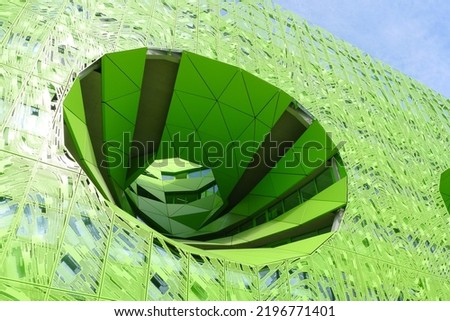 Engineering prowess with a huge hole like a meteor in a green building in Lyon Confluence, France Royalty-Free Stock Photo #2196771401