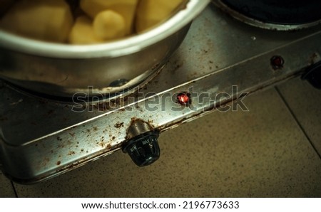 Cooking on a dirty stove.Unsanitary conditions in the kitchen. A pot of potatoes on a rusty electric stove. Royalty-Free Stock Photo #2196773633