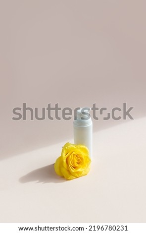 One yellow rose and jar of cream on pastel light background with sunlight and shadows. Beautiful composition for the design in the style of minimalism. New Naturalism concept. Сopy space