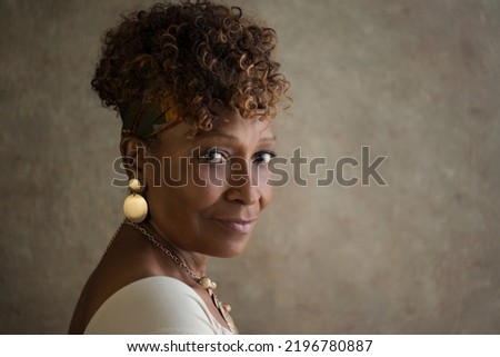 Portrait of a beautiful elderly 70-year-old African-American grandma spokesperson looking back over shoulder with ad or copy space for your ad Royalty-Free Stock Photo #2196780887