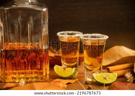 Tequila, shots with autumn decoration, with dry leaves on wooden