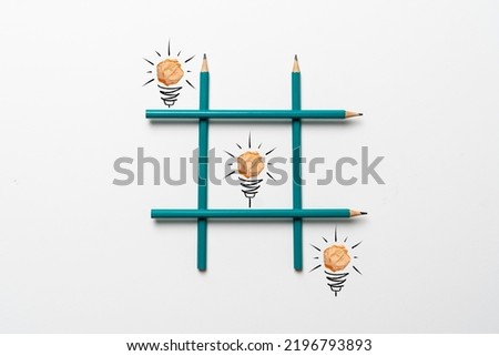 simple creative idea of drawn paper light bulbs in the tic tac toe grid made of crayons on pastel background Royalty-Free Stock Photo #2196793893