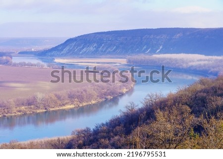 Beautiful view of the hilly valley with the river soothing winter nature. Background with copy space for text