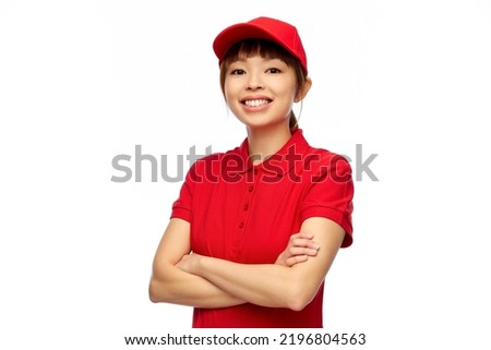 profession, job and people concept - happy smiling delivery woman in red uniform with crossed arms over white background Royalty-Free Stock Photo #2196804563