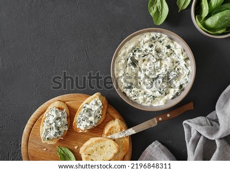 Spinach appetizer or dip with bread, top view, dark background, copy space Royalty-Free Stock Photo #2196848311
