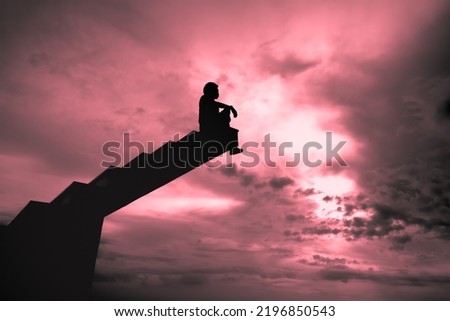 Silhouette of A man standing on the staircase at the beautiful sunset on sky