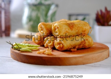 Indonesian Snack Sosis Solo and Green Chili Peppers. Sosis solo is shredded chicken wrapped with spring roll and deep fried with beaten egg Royalty-Free Stock Photo #2196875249