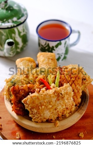 Indonesian Food Gorengan or Deep Fried Snacks on Wooden Bowl. There are fried tempeh, fried mashed potato and sosis solo Royalty-Free Stock Photo #2196876825