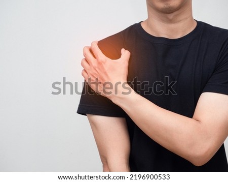 Man feels pain his shoulder isolated studio shot Royalty-Free Stock Photo #2196900533