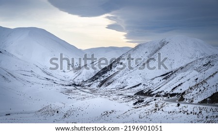 The long and winding road at Lindis Pass covered in snow, South Island.
