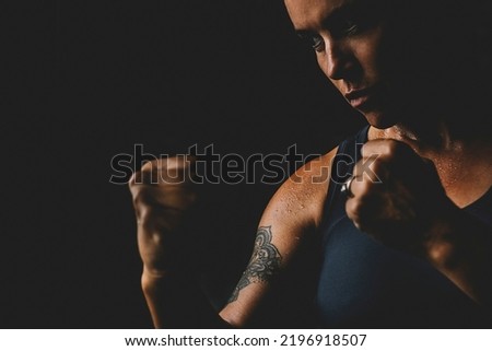 Middle age mature lady looking bad in boxe defence posture pose. Concept of woman athlete training hard. Empowerment and sport activity for female people in dark black background copy space. Lifestyle Royalty-Free Stock Photo #2196918507