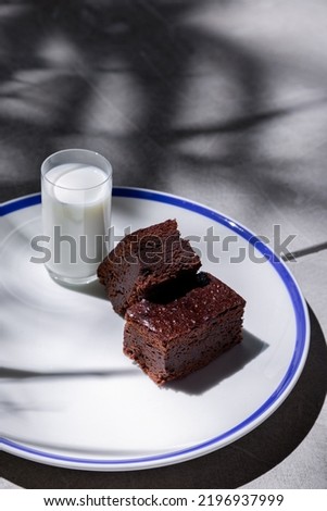 Pieces of chocolate pie with a glass of pullets in a plate that stands on a concrete table