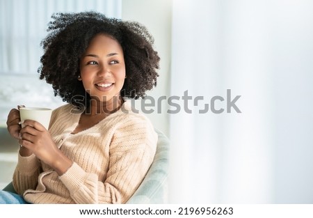 Portrait of young beautiful African American black woman hands holding coffee cup morning spring time in white bedroom. Happy cheerful relaxing in winter. Wakeup university lifestyle concept Royalty-Free Stock Photo #2196956263