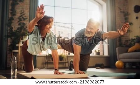 Happy Smiling Senior Couple Doing Gymnastics and Yoga Stretching Exercises Together at Home on Sunny Morning. Concept of Healthy Lifestyle, Fitness, Recreation, Couple Goals, Wellbeing and Retirement. Royalty-Free Stock Photo #2196962077