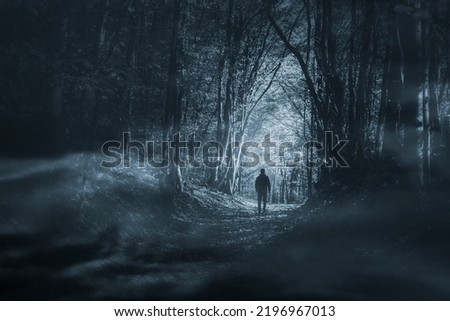 man in dark woods at night
