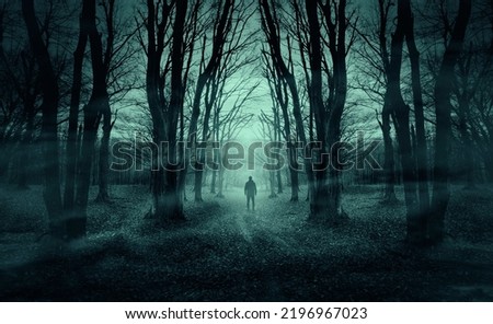 man on dark forest road at night, horror halloween landscape Royalty-Free Stock Photo #2196967023