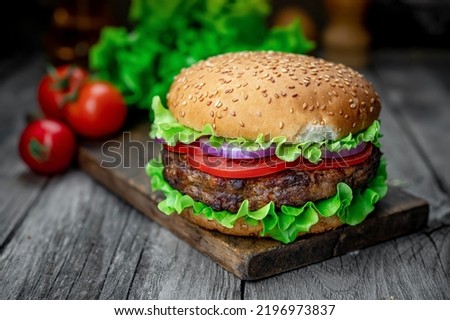 Fresh tasty burger on wood table. Delicious grilled food in a restaurant