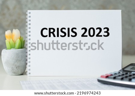 Crisis 2023 is written on a sheet of notepad on a desk, a business concept