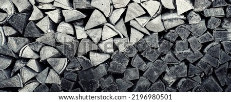 Panoramic view of chopped timbers stacked in woodpile on fireplace. Firewoods black and white background.