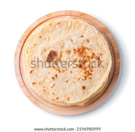 Traditional chapati tortillas on a blackboard are isolated on a white background in close-up. Indian cuisine. Top view Royalty-Free Stock Photo #2196980999