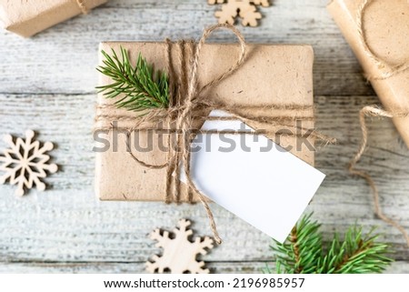 Christmas present with white blank mockup tag and fir tree branches on white background. Copy space for text and design on gift or present label. Eco friendly, zero waste, plastic free.