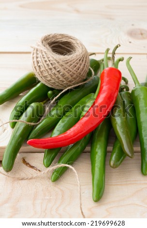 Red and green hot chili peppers on wooden boards 