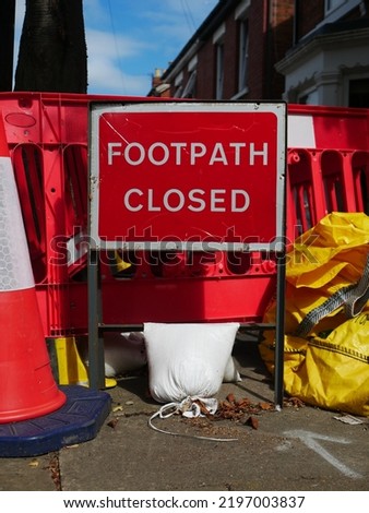Footpath closed sign with cones and barriers on suburban British street showing concept of limited accessibility to pedestrians or mobility scooters
