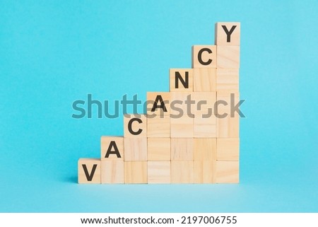 the word VACANCY is written on a wooden cubes. blocks on a bright blue background. corporate hierarchy concept and multilevel marketing
