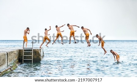 Sequence of jump. Moments of schoolboy jumping from stone pier with ladder into sea doing tricks in combined image sequence Royalty-Free Stock Photo #2197007917