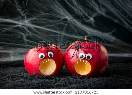 Halloween background.Scary apples with spiders on a dark background. Halloween food. Copy space.