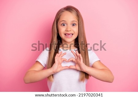 Photo of adorable lovely girl toothy smile hands fingers show heart symbol isolated on pink color background