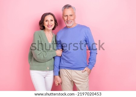 Portrait of two aged idyllic people hold hands toothy smile look camera isolated on pink color background
