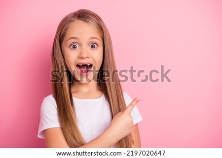 Portrait of astonished charming little girl open mouth indicate finger empty space isolated on pink color background Royalty-Free Stock Photo #2197020647