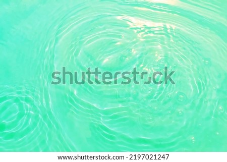Defocus blurred transparent blue colored clear calm water surface texture with splashes and bubble. Trendy abstract nature background. Water wave in sunlight with copy space. Blue watercolor shining.