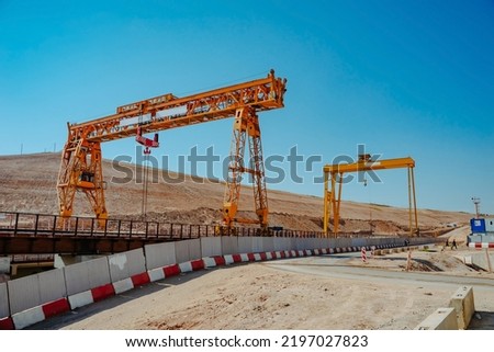 Two gantry cranes on highway construction. Big yellow gantry cranes. The work of lifting equipment.  Royalty-Free Stock Photo #2197027823