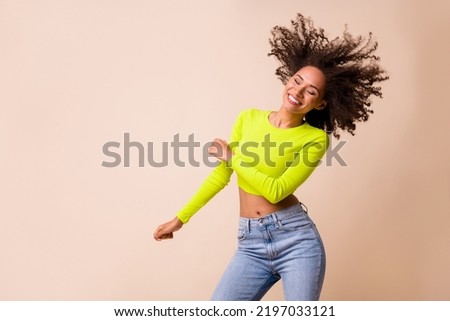 Portrait of young attractive smiling girl wear yellow top dancing good mood party isolated on beige color background
