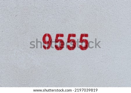 Red Number 9555 on the white wall. Spray paint.
