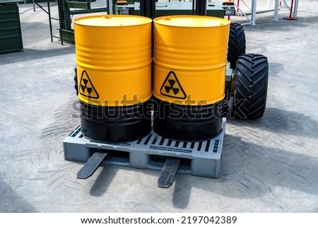 Barrels with radioactive waste. Radiation symbol on yellow metal containers. Two barrels with radiation symbol on pallet. Transportation of dangerous containers on forklift. Working with radiation Royalty-Free Stock Photo #2197042389