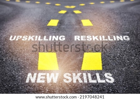 Self development for well being concept and changing skill demand idea. New skills, reskilling and upskilling written on asphalt road Royalty-Free Stock Photo #2197048241