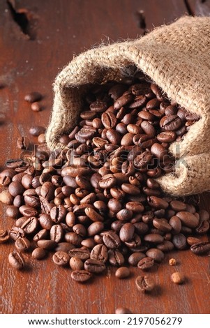 A coffee bean is a seed of the Coffea plant and the source for coffee. It is the pip inside the red or purple fruit often referred to as a coffee cherry. Just like ordinary cherries, the coffee fruit  Royalty-Free Stock Photo #2197056279