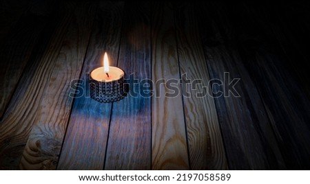 Candle light burning on wooden table memorial theme banner.