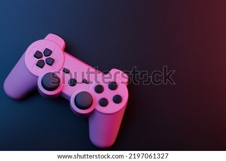 Pink video game controller, joystick for game console isolated on black background. Gamer control device close-up