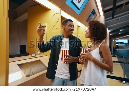 A couple buys a movie ticket at the box office. High quality photo