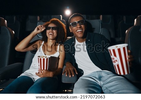 Couple watching comedy in 3d glasses with popcorn. High quality photo