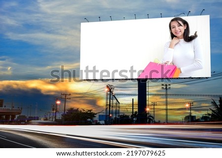 Portrait of young attractive beautiful woman hold the shopping bags advertise on billboard blank for outdoor advertising poster or blank billboard for advertisement