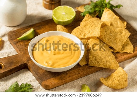 Homemade Yellow Queso Cheese Dip with Tortilla Chips and Lime Royalty-Free Stock Photo #2197086249