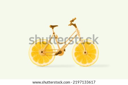 Food delivery concept. Creative bicycle with wheels made with slices of lemon on isolated pale yellow background. Minimal abstract summer, organic, raw fruit transport scene. Sustainable lifestyle. Royalty-Free Stock Photo #2197133617